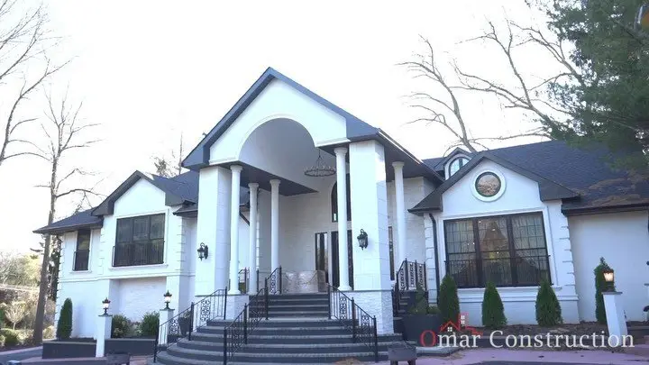 Front of a large white custom home with columns and a grand entrance in Clifton, NJ