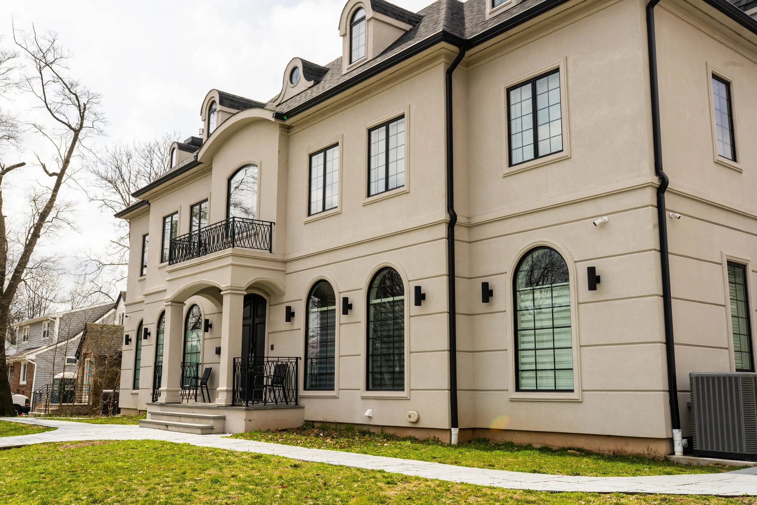 Custom home with arched windows and a front balcony built by Omar Construction in New Jersey