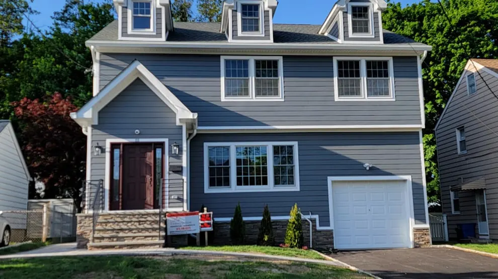 The new Nutley, NJ home we built after taking down the original house, with gray siding, three dormers and a new front entry