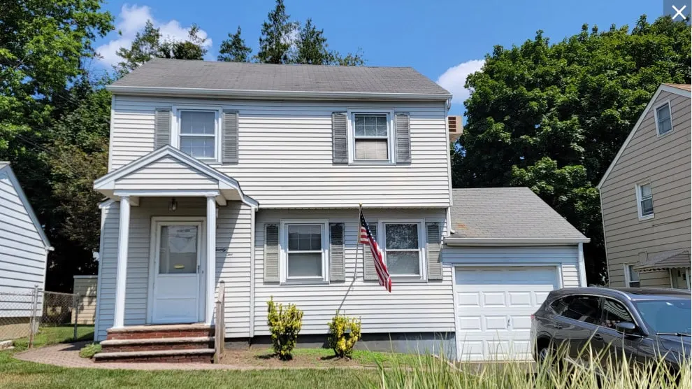 The original Nutley, NJ house before we took it down, with white vinyl siding and a small front porch